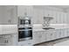 Close-up of a modern kitchen featuring stainless steel appliances, white cabinets, and stylish tile backsplash at 11691 N Luckenbach St, Surprise, AZ 85388