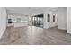 Bright and airy living room featuring wood-look tile flooring, white walls, and sliding glass doors to the backyard at 11691 N Luckenbach St, Surprise, AZ 85388