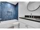 Modern bathroom with tub, blue subway tile, and black countertop vanity at 2126 E Watson Dr, Tempe, AZ 85283