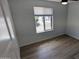 Bright bedroom featuring wood-look floors and a window with neighborhood views at 4442 E Aire Libre Ave, Phoenix, AZ 85032