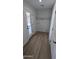 Laundry room with wood-look floors, white walls, shelving, and a glass door to the backyard at 4442 E Aire Libre Ave, Phoenix, AZ 85032
