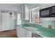 Charming kitchen boasts white cabinets, green countertops, and a backyard view at 2246 W Mulberry Dr, Phoenix, AZ 85015