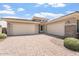 Expansive three-car garage with brick accents, complemented by mature landscaping in front of home at 28389 N 131St Dr, Peoria, AZ 85383