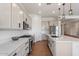 Modern kitchen with white cabinets, stainless steel appliances, and a view into the dining and living areas at 28389 N 131St Dr, Peoria, AZ 85383