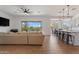 Open-concept living area with wood floors, modern lighting and a large kitchen island with barstool seating at 28389 N 131St Dr, Peoria, AZ 85383