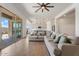 Living room with a large sectional sofa, sliding glass doors, and a view of the kitchen at 28389 N 131St Dr, Peoria, AZ 85383