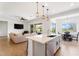 Bright, open-concept living space flows into the kitchen and dining area with modern finishes and natural light at 28389 N 131St Dr, Peoria, AZ 85383