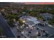 Stunning aerial view of an expansive property with a circular driveway and beautifully landscaped grounds at dusk at 6620 E Stallion Rd, Paradise Valley, AZ 85253