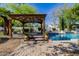 A backyard patio featuring a pergola, lush landscaping, and a view of the refreshing pool at 6620 E Stallion Rd, Paradise Valley, AZ 85253