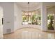 Bright dining area with travertine floors and backyard views through curved bay windows at 6620 E Stallion Rd, Paradise Valley, AZ 85253