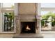 Elegant fireplace with decorative mantel, travertine floors and large windows with courtyard views at 6620 E Stallion Rd, Paradise Valley, AZ 85253
