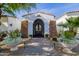 Elegant home entrance with a decorative iron gate, stone accents and beautiful landscaping at 6620 E Stallion Rd, Paradise Valley, AZ 85253