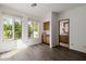 Sun-filled bonus room with hardwood floors, wet bar, and views of lush greenery through large windows at 6620 E Stallion Rd, Paradise Valley, AZ 85253