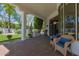 Relaxing covered patio with brick flooring and comfortable wicker chairs overlooking the manicured backyard at 6620 E Stallion Rd, Paradise Valley, AZ 85253