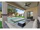 Inviting covered patio with an outdoor seating area overlooking a refreshing pool and landscaped backyard at 1264 E Walnut Rd, Gilbert, AZ 85298