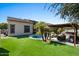 Lush backyard showcasing the home's exterior, a pool, outdoor kitchen and pergola at 1264 E Walnut Rd, Gilbert, AZ 85298