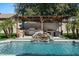 Inviting backyard featuring a pool with a waterfall feature and an outdoor kitchen with a pergola at 1264 E Walnut Rd, Gilbert, AZ 85298