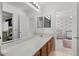 Bright bathroom with a large mirror, modern vanity, and a peek into an adjacent bedroom at 1264 E Walnut Rd, Gilbert, AZ 85298