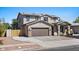Inviting two-story home featuring a two-car garage, desert landscaping, and solar panels for energy efficiency at 1264 E Walnut Rd, Gilbert, AZ 85298