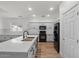 Bright kitchen showcasing white cabinets, island with sink, and stainless-steel appliances for a modern feel at 1264 E Walnut Rd, Gilbert, AZ 85298