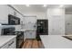 White kitchen with stainless steel appliances, quartz countertops, and hardwood floors at 1264 E Walnut Rd, Gilbert, AZ 85298