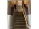 Carpeted staircase with decorative molding and a wooden handrail leads to the upper level of the home at 1542 E Chaparral Pl, Casa Grande, AZ 85122