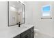 Bathroom featuring a large mirror, sleek vanity, quartz counters and tiled shower with built-in niche at 18083 W Amber Dr, Goodyear, AZ 85338