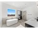 Modern bathroom with a soaking tub, walk-in glass shower, and quartz countertops at 18083 W Amber Dr, Goodyear, AZ 85338