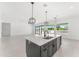 Open-concept kitchen features a central island, modern lighting, and views of the living area at 18083 W Amber Dr, Goodyear, AZ 85338