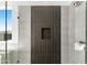 The spa-like shower features modern tiling, glass enclosure and custom niche at 18083 W Amber Dr, Goodyear, AZ 85338