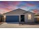 Charming single-story home featuring a blue garage door, desert landscaping, and a welcoming entryway at 3409 E Alexander Dr, San Tan Valley, AZ 85143