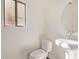 Bright powder room with pedestal sink, round mirror, and window at 8415 S 47Th Ln, Laveen, AZ 85339