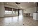 Bright living room features neutral colors, tile floors, large windows, dining table, and a ceiling fan at 20447 N 266Th Ave, Buckeye, AZ 85396