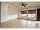 Bright living room features neutral colors, tile floors, large windows, and a ceiling fan at 20447 N 266Th Ave, Buckeye, AZ 85396