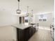 Open kitchen with island and view into living area at 36853 W La Paz St, Maricopa, AZ 85138