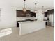 Modern kitchen with island, stainless steel appliances, and dark wood cabinetry at 36853 W La Paz St, Maricopa, AZ 85138