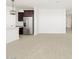 Living room with kitchen and stainless steel fridge at 36853 W La Paz St, Maricopa, AZ 85138