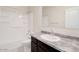 Bathroom features a vanity with dark cabinets, granite countertop, and a shower-tub combo at 38125 W Excussare Way, Maricopa, AZ 85138