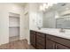 Bathroom featuring double sinks, wood cabinets and a glass-enclosed shower at 18156 W Cielo Grande Ave, Surprise, AZ 85387