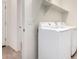 Bright laundry room features white washer and dryer units, complemented by practical shelving above at 18156 W Cielo Grande Ave, Surprise, AZ 85387