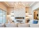 Open-concept living room with decorative stone fireplace, modern chandelier, and neutral color palette at 2072 E Blackhawk Ct, Gilbert, AZ 85298