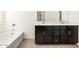 Elegant bathroom with dark brown vanity and double sinks at 36893 W La Paz St, Maricopa, AZ 85138