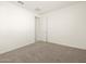Spacious bedroom with neutral carpeting and a door at 36893 W La Paz St, Maricopa, AZ 85138