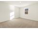 Well-lit bedroom featuring neutral carpeting and a window at 36894 W La Paz St, Maricopa, AZ 85138