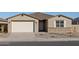 Single story home with a two-car garage, neutral color scheme and landscaping at 36894 W La Paz St, Maricopa, AZ 85138