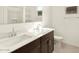 Modern bathroom featuring a double vanity with white countertops, dark wood cabinets, and a separate toilet area at 4958 W Hunter Trl, San Tan Valley, AZ 85144