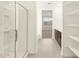 Bright bathroom with glass-enclosed shower, open shelving, and a view into the bedroom at 4958 W Hunter Trl, San Tan Valley, AZ 85144