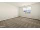 A well lit bedroom with carpet and a window at 4958 W Hunter Trl, San Tan Valley, AZ 85144