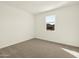 A bright and airy bedroom with neutral carpet, a window providing natural light, and minimalist decor at 4958 W Hunter Trl, San Tan Valley, AZ 85144