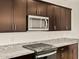 New kitchen with dark cabinets, granite countertops, stainless appliances, and gas cooktop at 4958 W Hunter Trl, San Tan Valley, AZ 85144